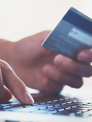 A person setting at a laptop reading a credit card